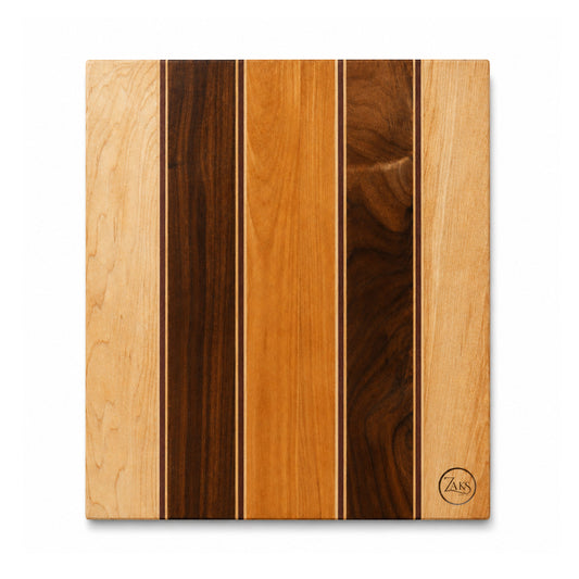 A square wooden cutting board with vertical stripes of different wood grain, featuring a circular 'ZAN' logo engraved in the bottom right corner, set against a plain white background.